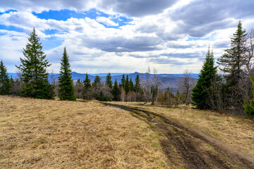 South Ural forest road with a unique landscape, vegetation and diversity of nature in spring.
