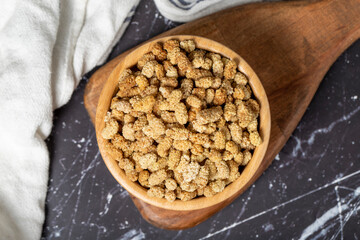 Dried mulberry. Sun-dried organic white dried mulberry in wooden bowl. Superfood, Vegetarian food concept. healthy snacks. Top view
