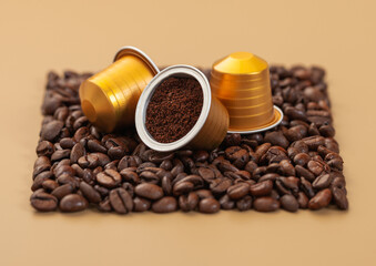 Coffee capsules suitable for machine on square coffee beans texture on beige background with ground coffee
