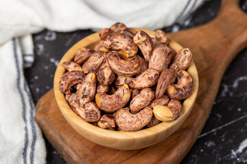 Cashew nuts . Roasted cashew nuts with shell in wooden bowl. Superfood. Vegetarian food concept. Healthy snacks