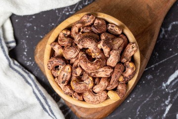 Cashew nuts . Roasted cashew nuts with shell in wooden bowl. Superfood. Vegetarian food concept. Healthy snacks. Top view