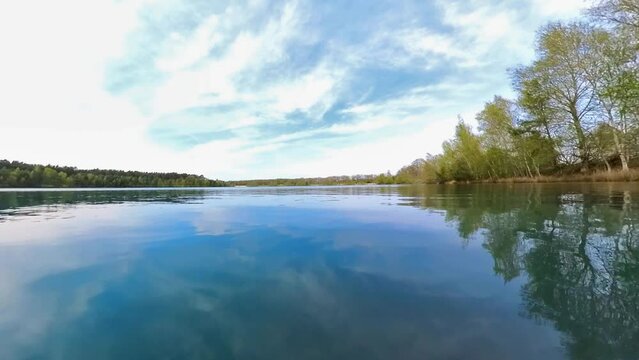 idyllischer See mit kristallklarem Wasser, kleinen Wellen, Sonnenschein blauer Himmel, Drohne, Insel