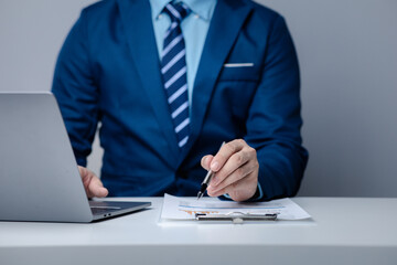 Businessman sits in a private office at his company and is reviewing company financial documents, senior management checking financial information for accuracy. Financial management.