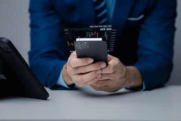 Businessman holding a device with a stock chart hologram, investing, using technology to invest in stocks. The concept of using technology in trading and analyzing stocks.