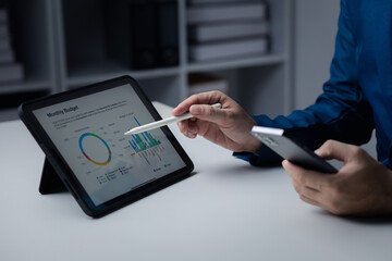 Person looking at data on tablet, businessman owner of startup company checking financial documents on tablet. The concept of using technology to manage information documents.