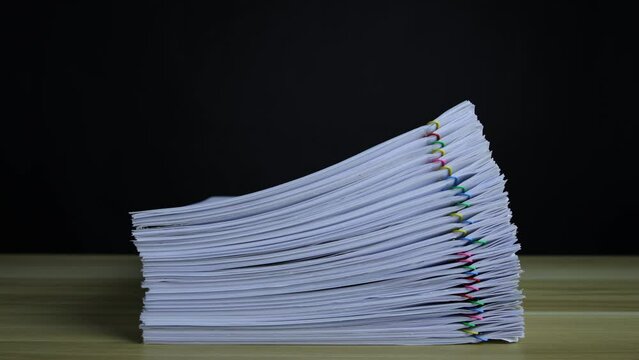 Stacks of paper documents, clippings, growing on a wooden table, organizing documents &ndash; 4K Stop Motion, Stack Files Overload
