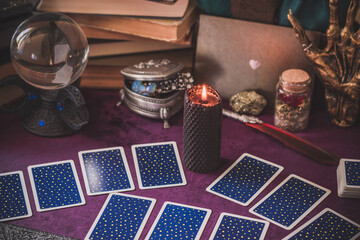 Tarot cards and candles, witch magic bottles . Wicca, esoteric, divination and occult background with vintage magic objects for mystic rituals