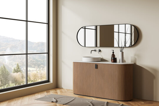 Beige bathroom interior with sink and dresser, decoration and panoramic window