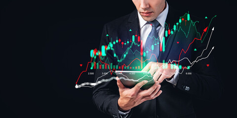Businessman using tablet, forex diagrams and stock market candlesticks chart