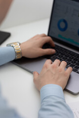 Close up of a person typing on a laptop, doing analysis and studying.
