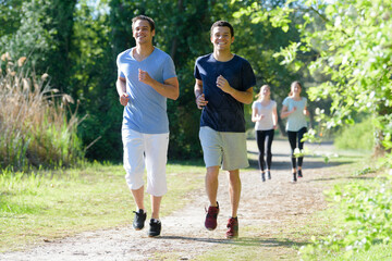 Obraz premium two men and two women jogging in the park