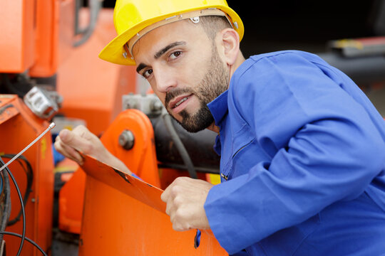 portrait of young male engineer working with machinery