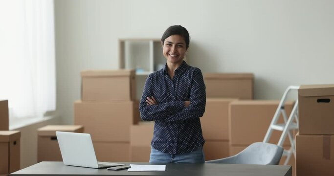 Young Indian woman, individual entrepreneur pose at workplace with arms crossed smile look at camera feels satisfied with sales, own small business growth. Retail services, commerce, entrepreneurship