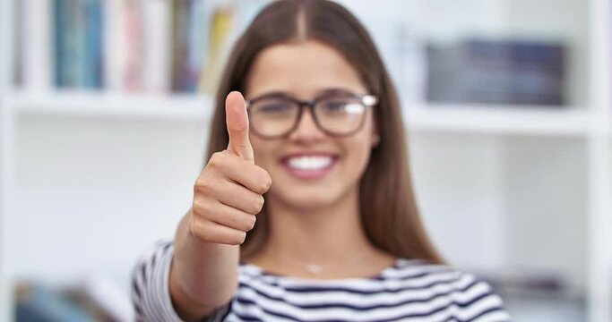 Woman, portrait and thumbs up in learning success, education goals or school target in university campus library. Smile, happy student and good luck thumb or finger for college vote or winner review