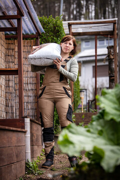 female professional gardener works in the garden