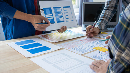 Close-up ux developers and ui designers use augmented reality to brainstorm on mobile app interface...