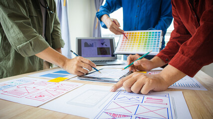 Close-up ux developers and ui designers use augmented reality to brainstorm on mobile app interface wireframe designs on modern office desks. Creative digital development office