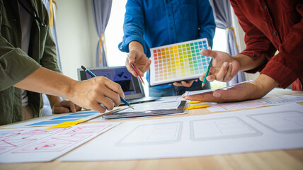 Close-up ux developers and ui designers use augmented reality to brainstorm on mobile app interface wireframe designs on modern office desks. Creative digital development office