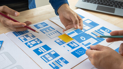 Close-up ux developers and ui designers use augmented reality to brainstorm on mobile app interface...