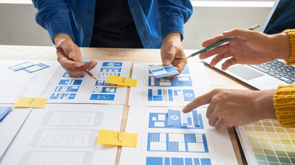 Close-up ux developers and ui designers use augmented reality to brainstorm on mobile app interface...