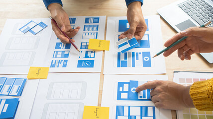 Close-up ux developers and ui designers use augmented reality to brainstorm on mobile app interface...