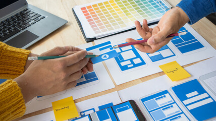 Close-up ux developers and ui designers use augmented reality to brainstorm on mobile app interface...