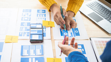 Close-up ux developers and ui designers use augmented reality to brainstorm on mobile app interface...
