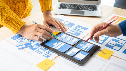 Close-up ux developers and ui designers use augmented reality to brainstorm on mobile app interface...