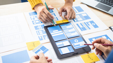 Close-up ux developers and ui designers use augmented reality to brainstorm on mobile app interface...