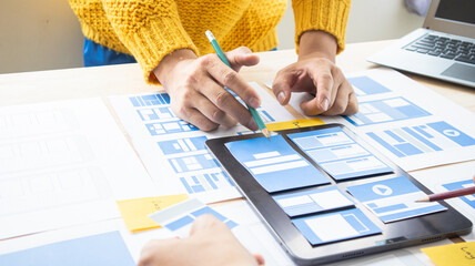Close-up ux developers and ui designers use augmented reality to brainstorm on mobile app interface...
