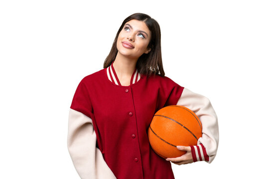 Young Russian woman playing basketball over isolated chroma key background thinking an idea while looking up