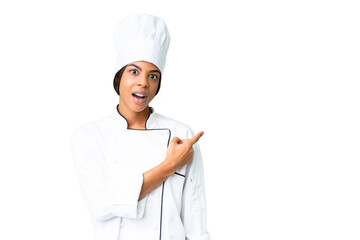 Young African American chef over isolated chroma key background surprised and pointing side