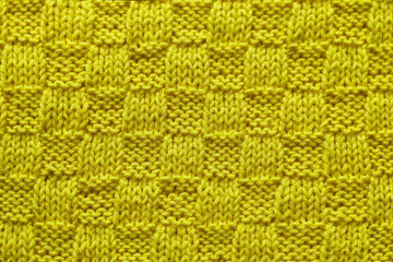 Yellow citron seamless knited texture close up. Knitted chess pattern. Knited background.