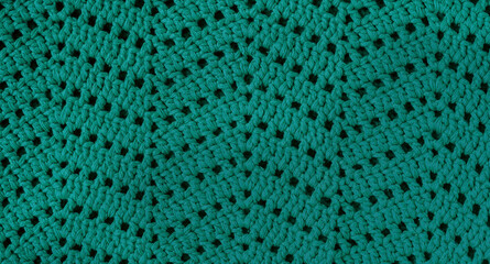 Turquoise crochet texture with chevron stitch. Crochet fabric with zigzag pattern.
