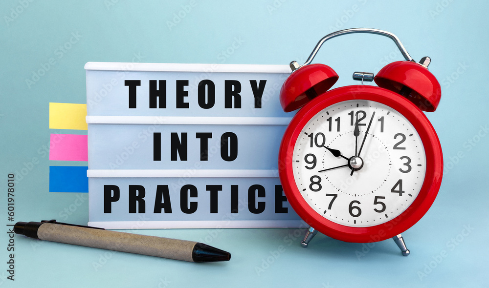 Poster text theory into practice written on the lightbox with alarm clock and colorfull stickers on blue ba