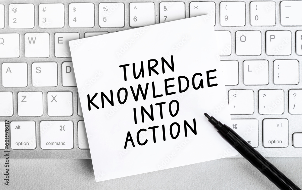 Poster white paper with text turn knowlege into action lying on the keyboard