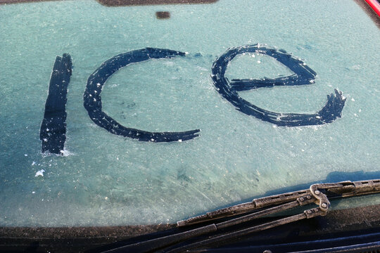 The word ice spelt on the Icey windscreen of a cold car in the Winter. 