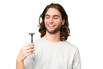 Young handsome man shaving his beard over isolated background with happy expression