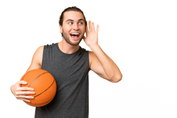 Young basketball player man over isolated background listening to something by putting hand on the ear