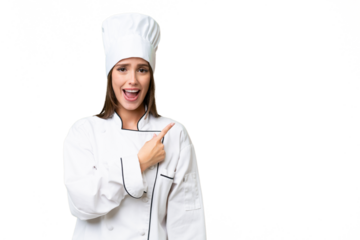 Young chef caucasian woman over isolated background surprised and pointing side