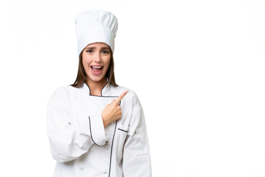 Young chef caucasian woman over isolated background surprised and pointing side