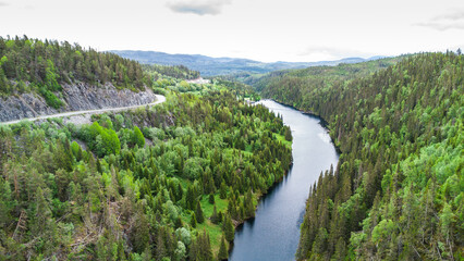 Beautiful landscape of Norway with a river, woods and a road