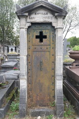 Rust deteriorations. Really old and decrepit door from a century-old cemetery (Père Lachaise, France)