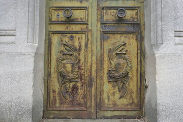 Rust deteriorations. Really old and decrepit door from a century-old cemetery (Père Lachaise, France)