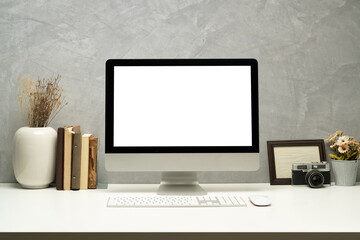 Stylish workplace with blank screen computer, picture frame and books. Empty screen for montage your graphic display