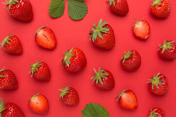 Strawberries with leaves on color background, top view