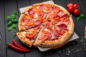 Italian pizza with ham, sausage, mushrooms, tomatoes and onions.