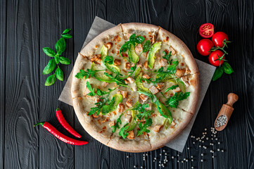 Delicious pizza with grilled chicken, avocado, and arugula.