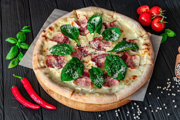 Tasty and big pizza with bacon and fresh salad
