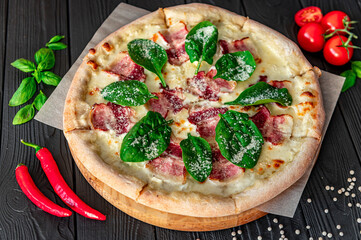 Tasty and big pizza with bacon and fresh salad